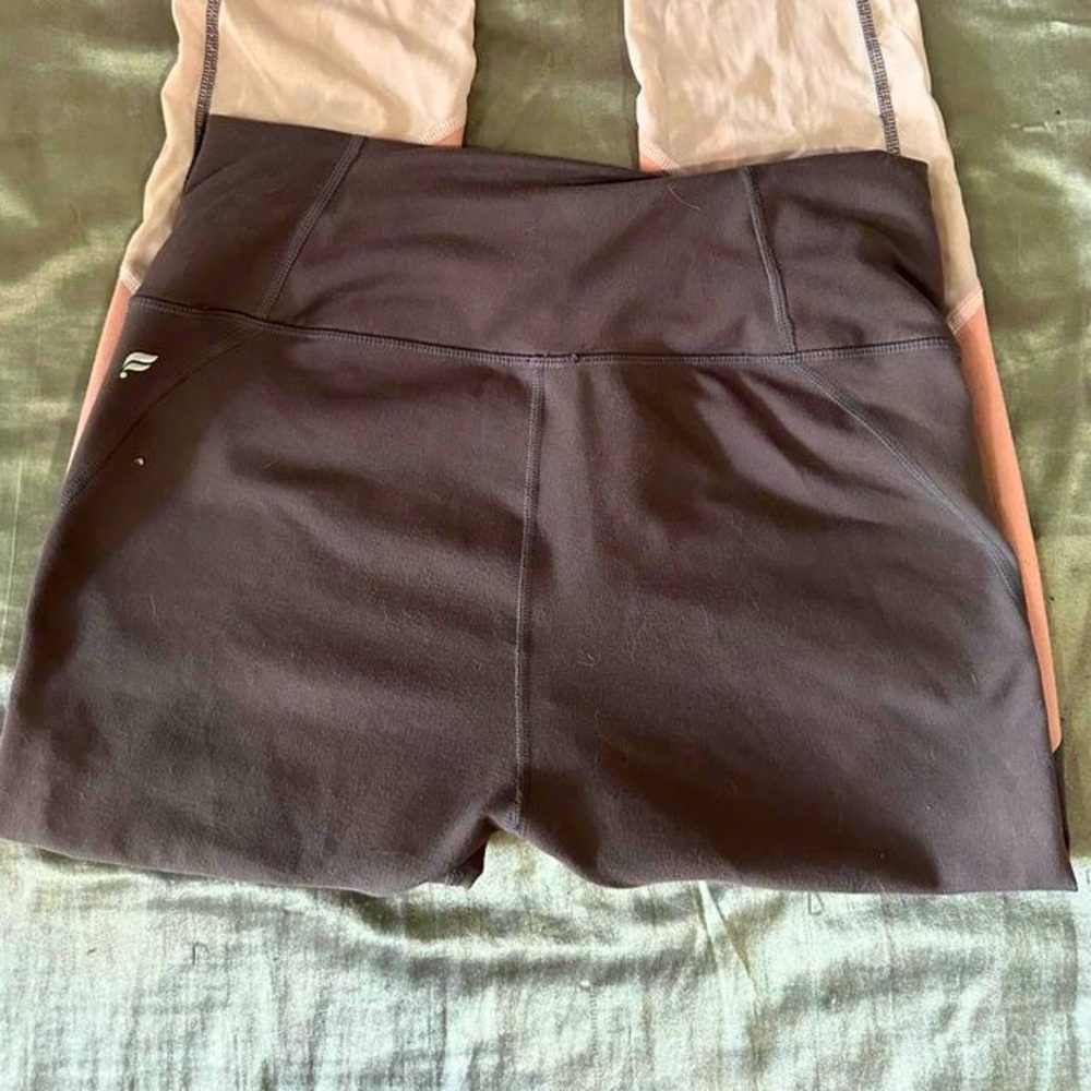 dark purple and pink workout leggings with sheer pinks cutouts in the legs